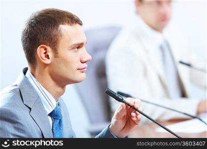 Image of businessmen speaking in microphone at conference