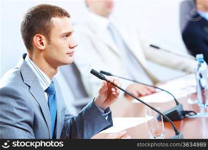 Image of businessmen speaking in microphone at conference