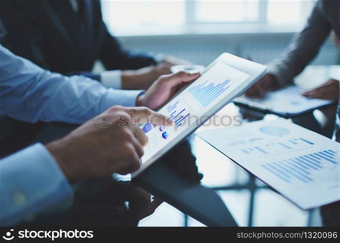 Image of businessperson pointing at document in touchpad at meeting