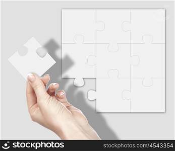 Image of colour puzzle pieces and human hand