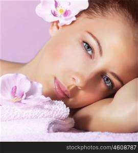 Image of cute young lady enjoying dayspa, closeup portrait of pretty woman with orchid flower in head on pink background, luxury spa resort, healthy lifestyle, beauty treatment and skin care concept