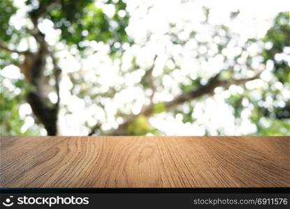 Image of dark wooden table in front of abstract blurred background of outdoor garden lights. can be used for display or montage your products.Mock up for display of product.