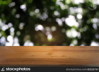 Image of dark wooden table in front of abstract blurred background of outdoor garden lights. can be used for display or montage your products.Mock up for display of product.