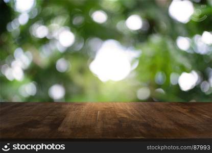 Image of dark wooden table in front of abstract blurred background of outdoor garden lights. can be used for display or montage your products.Mock up for display of product