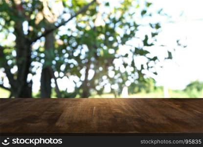 Image of dark wooden table in front of abstract blurred background of outdoor garden lights. can be used for display or montage your products.Mock up for display of product.