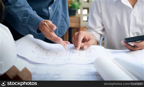 Image of engineer meeting for architectural project working with partner and engineering tools on workplace.