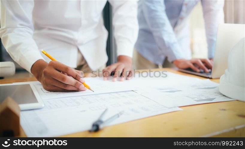 Image of engineer meeting for architectural project working with partner and engineering tools on workplace.