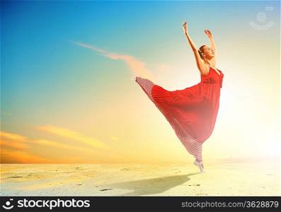 Image of female ballet dancing on coast against sunset background