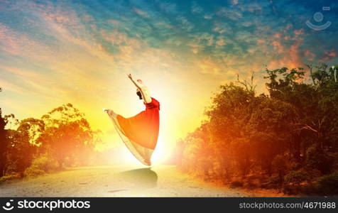 Image of female ballet dancing outdoor against sunset background. Female ballet dancer