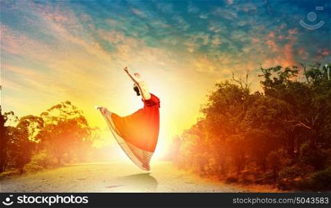 Image of female ballet dancing outdoor against sunset background. Female ballet dancer