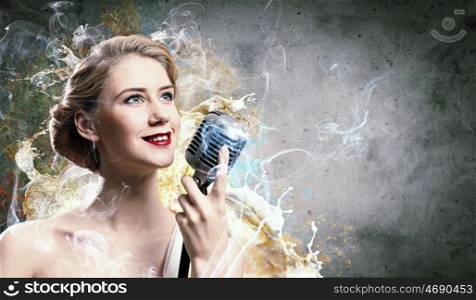 Image of female blond? singer holding microphone against smoke background