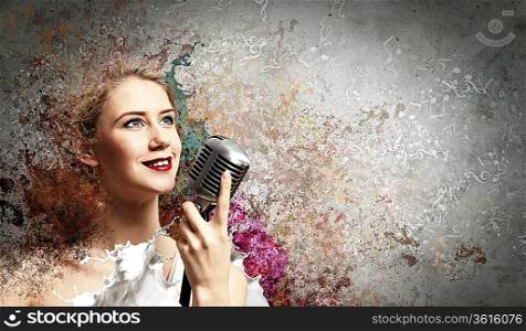 Image of female blondC singer holding microphone against color background