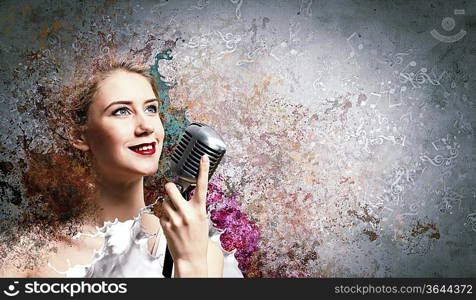 Image of female blondC singer holding microphone against color background