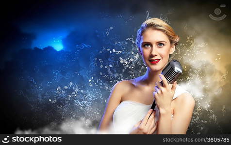 Image of female blonde singer holding microphone against smoke background