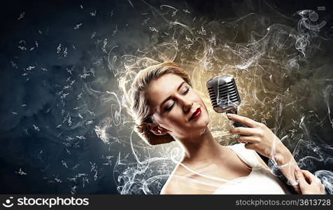 Image of female blonde singer holding microphone against smoke background with closed eyes