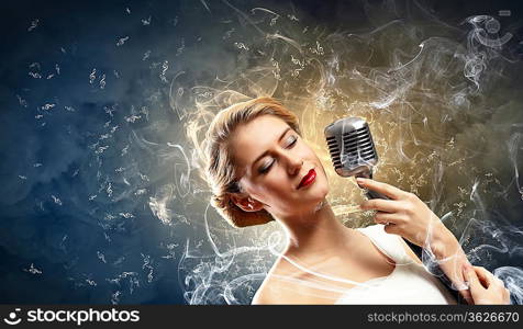 Image of female blonde singer holding microphone against smoke background with closed eyes