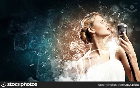 Image of female blonde singer holding microphone against smoke background with closed eyes