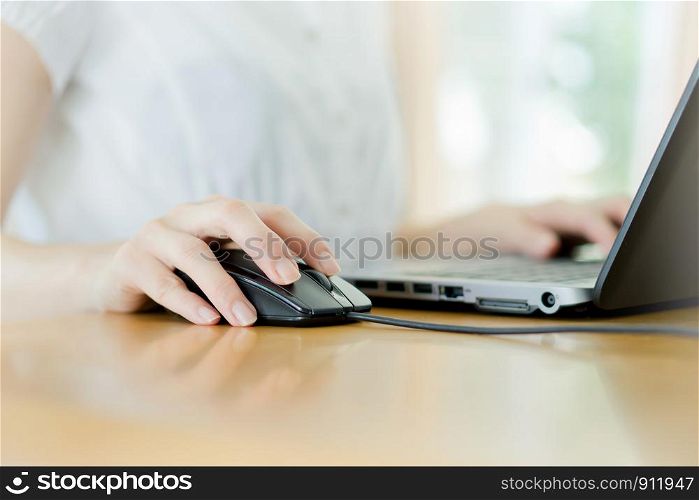 Image of female hands clicking computer mouse