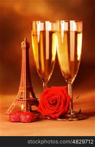 Image of festive romantic still life, alcoholic beverage, two glass with sparkling wine, honeymoon in Paris, travel to France, red fresh rose and heart-shaped candle, Valentine day, love concept