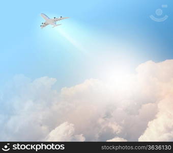 Image of flying airplane in clear sky with sun at background