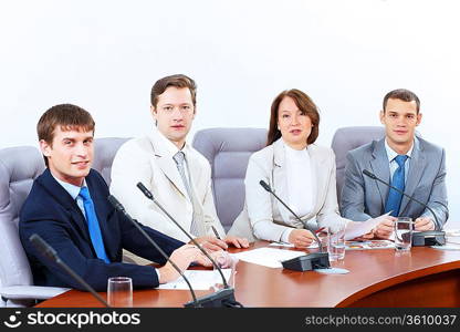 Image of four businesspeople discussing at meeting