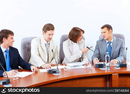 Image of four businesspeople discussing at meeting