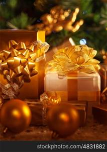 Image of golden gift boxes lying down under festive spruce tree, luxury presents, New Year party, wintertime home ornament, Christmas tree, beautiful shiny decorations, traditional celebration