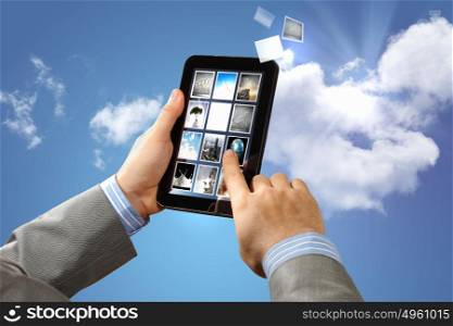 Image of hands touching pad. Image of businessman hands touching pad against sky background