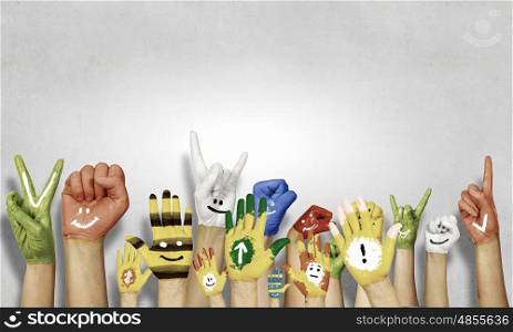 Image of human hands in colorful paint with smiles. Add color to life