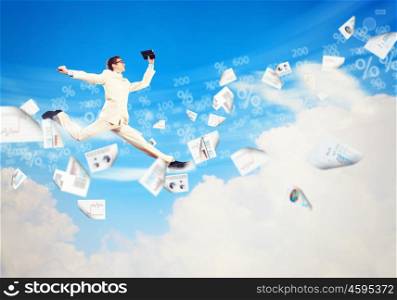 Image of jumping businessman. Image of a businessman jumping high against blue sky background
