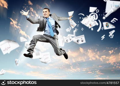 Image of jumping businessman. Image of a businessman jumping high against blue sky background