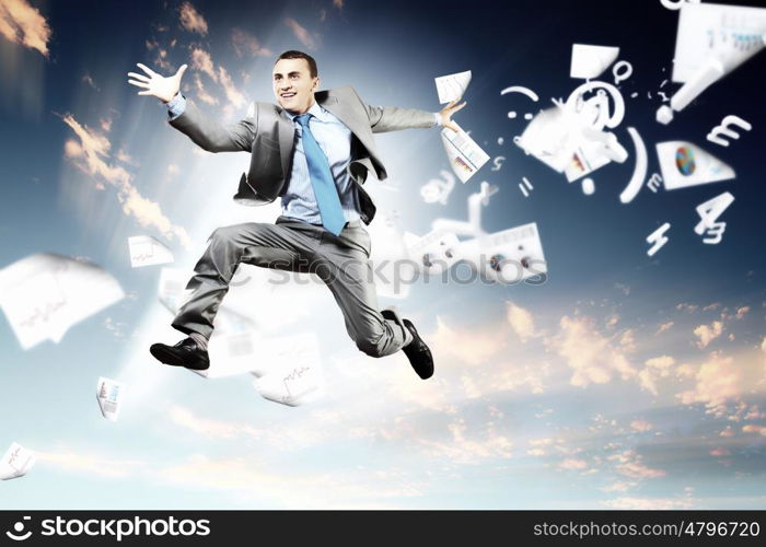 Image of jumping businessman. Image of a businessman jumping high against blue sky background