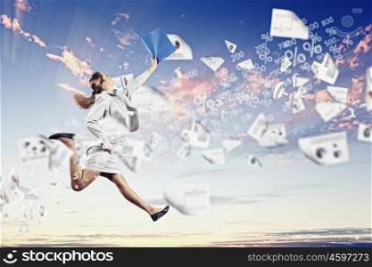 Image of jumping businesswoman. Image of a businesswoman jumping high against blue sky background