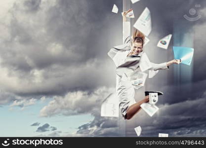 Image of jumping businesswoman. Image of a businesswoman jumping high against blue sky background