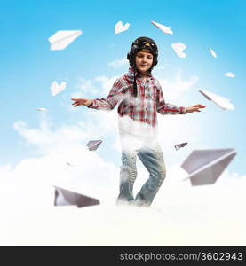 Image of little boy in pilots helmet with paper airplanes in background