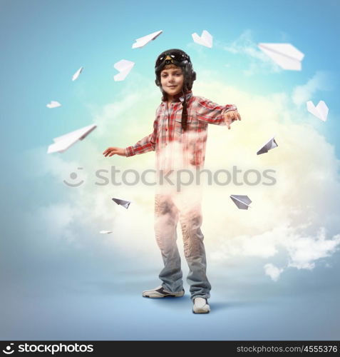 Image of little boy in pilots helmet with paper airplanes in background