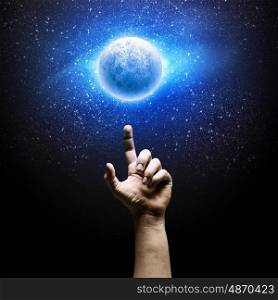 Image of moon. Human hand pointing at moon in space