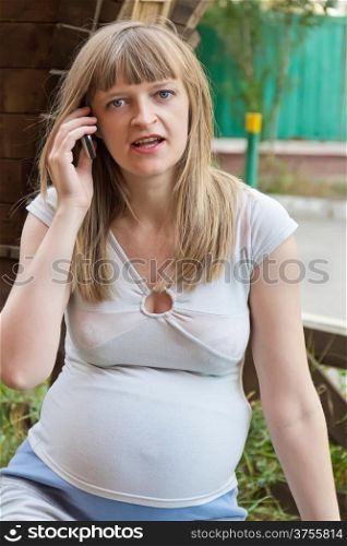 Image of pregnant woman talking by cellular