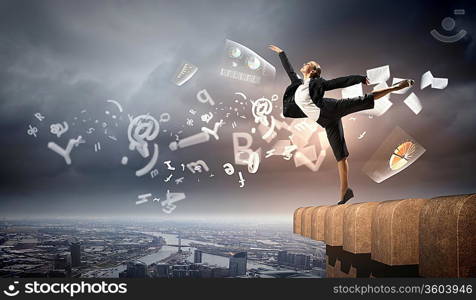 Image of pretty businesswoman balancing on the roof above cityscape