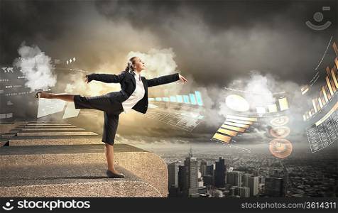 Image of pretty businesswoman balancing on the roof above cityscape