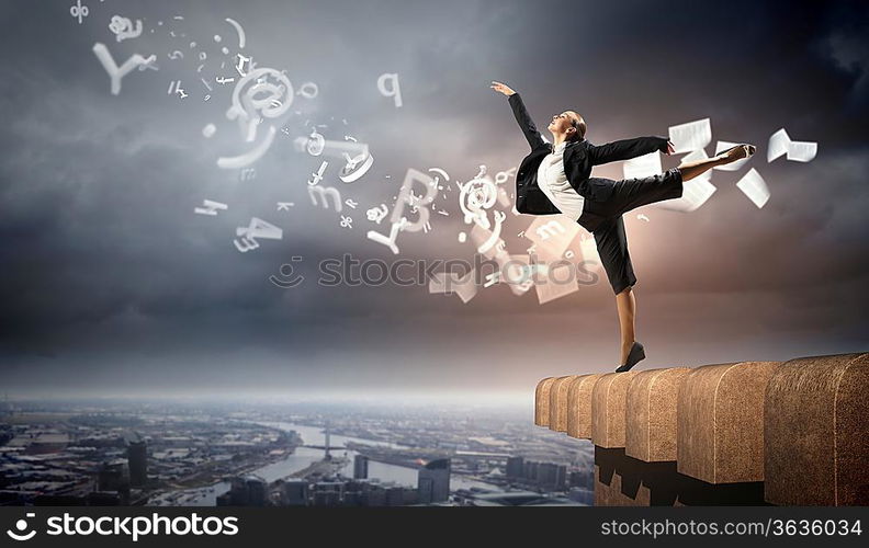 Image of pretty businesswoman balancing on the roof above cityscape