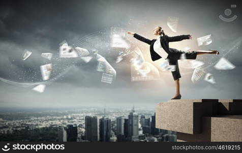 image of pretty businesswoman. Image of pretty businesswoman balancing on the roof above cityscape