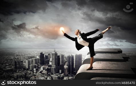 image of pretty businesswoman. Image of pretty businesswoman balancing on the roof above cityscape