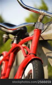 Image of red bike leaning against railing of boardwalk.