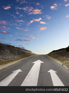 Image of road with white arrow directing forward