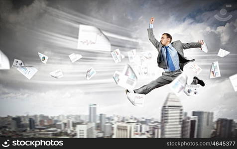 Image of running businessman. Image of a businessman jumping high against financial background