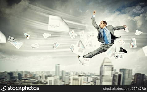 Image of running businessman. Image of a businessman jumping high against financial background