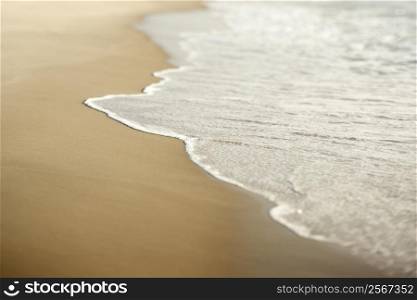 Image of sandy beach with waves.