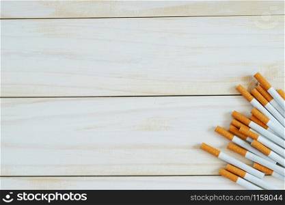 image of several commercially made pile cigarette on white wooden background. or Non smoking campaign concept, tobacco pattern top view.