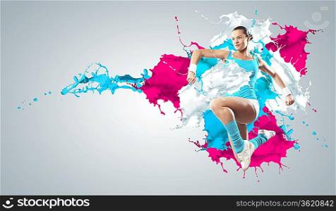 Image of sport girl in jump against color splashes background